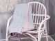 Bloomingville Quilt hellgrau mit rosa Streifen und Keder Rueckseite dunkel blau Baumwolle auf Rattan Stuhl rosa